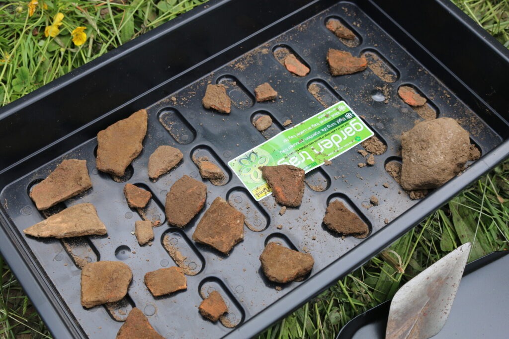 Pieces of ancient pot in a black tray
